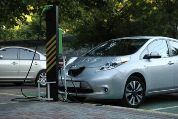 Charging modern electric car from station outdoors