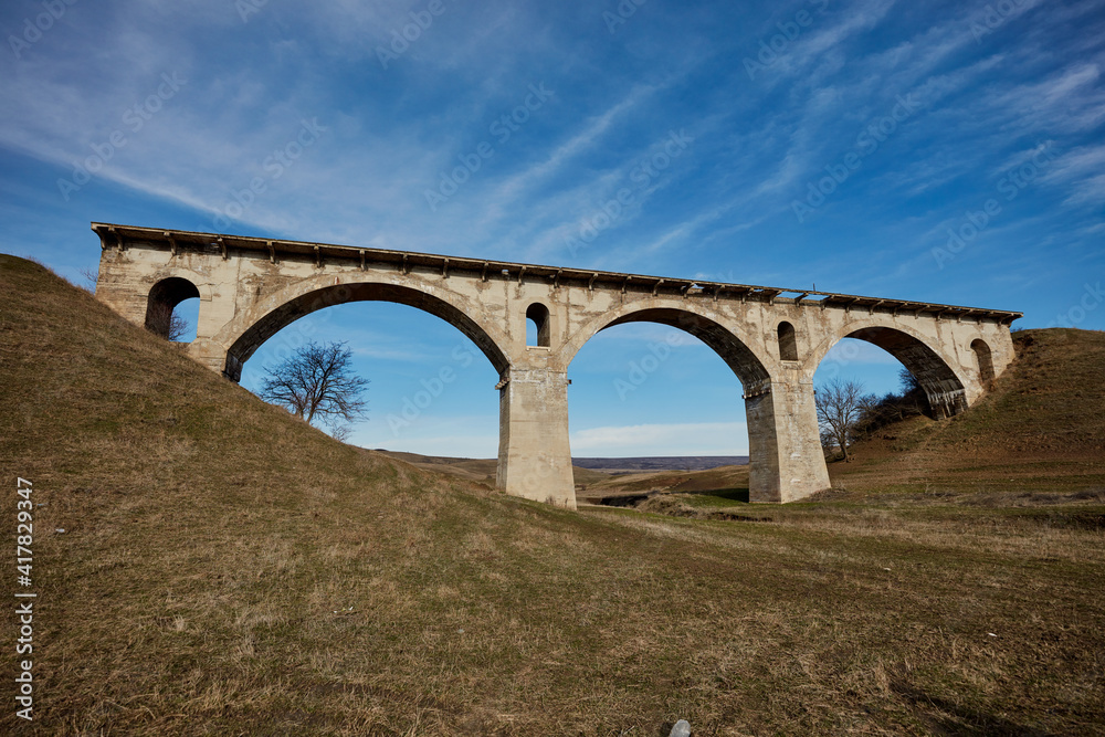 Old destroyed narrow-gauge railway bridge of the arched type