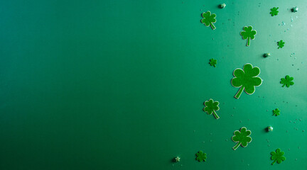 Wall Mural - Happy St. Patricks Day decoration concept. Flat lay, top view of clover leaves on green background with space for text.