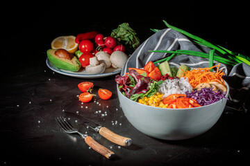 Wall Mural - Green vegan salad, rice and vegetable power bowl on a dark background. Healthy balanced food concept. Buddha bowl. Diet food