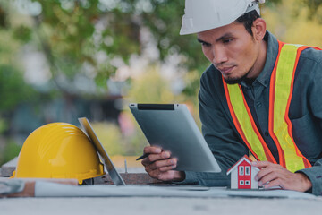 Engineer working on tablet and laptop in site construction