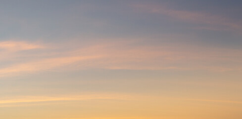 Beautiful sky painted by the sun leaving bright golden shades.Dense clouds in twilight sky in winter evening.Image of cloud sky on evening time.Evening sky scene with golden light from the setting sun