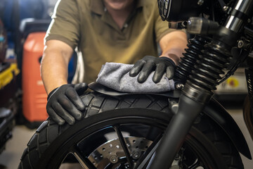 Biker man cleaning motorcycle , Polished and coating Wax Spray on front fender. repair and maintenance motorcycle concept.