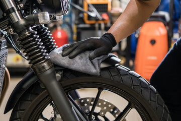 Biker man cleaning motorcycle , Polished and coating Wax Spray on front fender. repair and maintenance motorcycle concept.