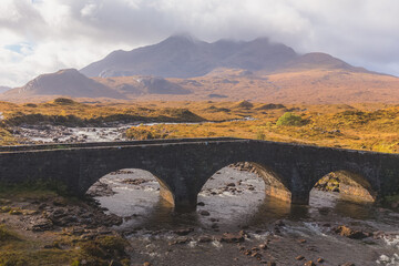 Wall Mural - Old stone bridge over River Sligachan with Black Cuillins mountain landscape on the Isle of Skye in the Scottish Highlands, Scotland.