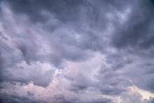 Heavy Rain Clouds, Cumulus Clouds Move Across The Sky. Soft Pink And Dark Blue Mix
