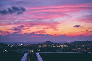 Wall Mural - Peaceful sunset in the city. Beautiful landscape with sea, purple sky and cityscape.