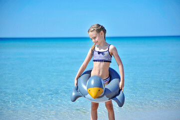 Wall Mural -  Summertime. Little girl swims in sea. Summer concept. Little girl on summer vacation.