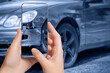A girl takes pictures on a smartphone of car damage at the scene of an accident for insurance compensation. Selective focus.