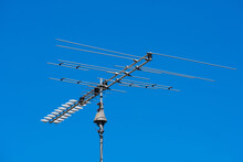Outdoor TV Antenna Mounted On Pole. Beautiful Blue Sky Background.