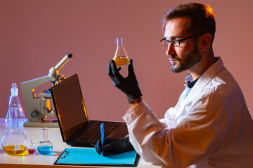 Poster - portrait of a male chemist in profile. a person with a test tube in his hands. a scientist in a chem