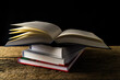 Books on wooden deck table and dark background.
