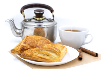 Wall Mural - Puff pastry. Composition with a cup of tea and a kettle. Close up. White background.