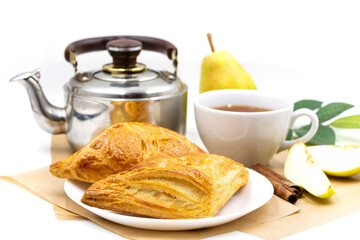 Wall Mural - Puff pastry with pears. Composition with a cup of tea and a kettle.