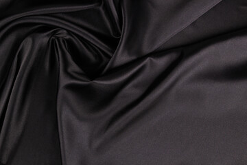 Wall Mural - Beautiful elegant black background with drapery and wavy folds of silk satin material texture. Top view