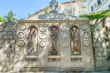 Wall Mural - Christian reliefs and icons nearby entrance of Inkerman cave monastery. This is Jesus, Mother, Peter, apostles and their names. Shot in Inkerman, Crimea. Inscription is 'St Clement male monastery'