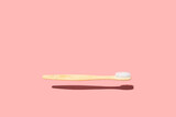 Fototapeta  - Levitating Wood Toothbrush On Pink Background. Trendy Zero Waste Wooden Toothbrush Concept.