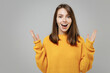 © ViDi Studio - Young smiling excited overjoyed positive excited shocked surprised woman 20s in casual knitted yellow sweater looking aside isolated on grey color background studio portrait. People lifestyle concept.