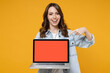 © ViDi Studio - Young smiling happy satisfied fun woman 20s in denim shirt white t-shirt point index finger on laptop pc computer with blank screen workspace area chat isolated on yellow background studio portrait