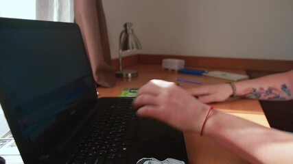 Poster - The student's hands are leafing through the magazine on the table near the computer. Learning Czech in your free time.