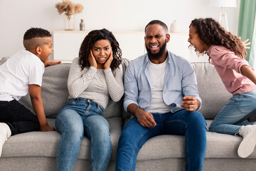 Angry black children fighting over their shocked parents