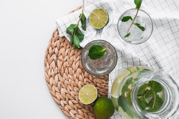 Poster - Detox water with lime fruit and mint leaves in jar and glasses. Flat lay, top view