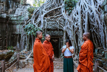 Woman Praying With Three Buddhist Monks At Temple In The Forest