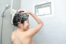 Young Woman Washing Her Head In The Shower By Shampoo