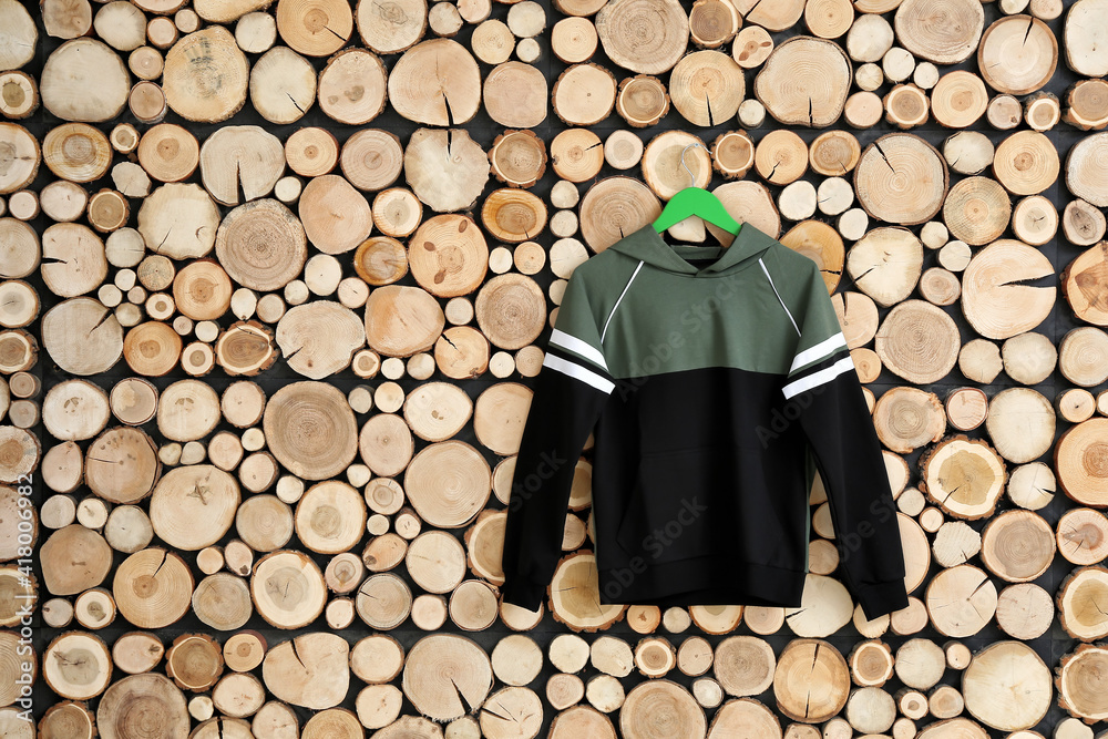 Hanger with clothes on wooden background