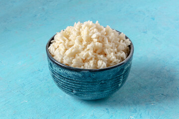 Cooked rice in a bowl on a blue background