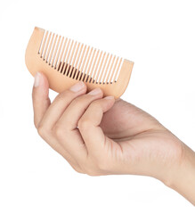 Sticker - Hand holding Wooden comb Isolated on White Background