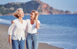 © luengo_ua - Outdoor portrait of smiling happy caucasian senior mother with her adult daughter hugging and walking on sea beach.
