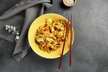 Canvas Print - Curry Udon Noodles. Asian curry udon in yellow plate with wooden chopstick on dark slate table. Asian, authentic food concept