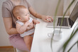 © Алина Троева - Close up portrait little baby boy funny facial expression sitting on mother's lap studying laptop. Young mom work from home with computer. Home office, parenthood. Remote work, distance education. .