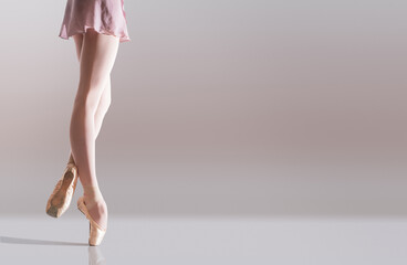 Wall Mural - Ballerina's feet in pointe shoes standing isolated on white background