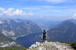 © Fauren - girl in black sportswear rejoices in defeating the Dachstein Krippenstein and enjoys the view of Hallstatter See and the adjacent village of Hallstatt with her hands over her head.