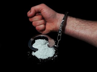 Handcuffed man and cocaine drug powder pile, arrested drug dealer