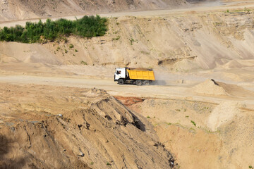 Wall Mural - Dump truck transports sand in open pit mine. In the production of concrete, concrete for the construction using coarse sand. Quarry in which sand and gravel is excavated from ground. Mining industry