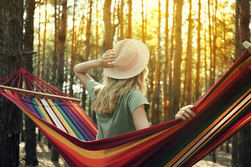 Wall Mural - Woman resting in hammock outdoors on summer day