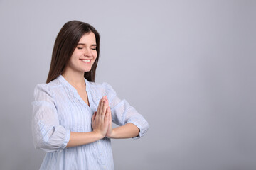 Canvas Print - Young woman meditating on grey background, space for text. Stress relief exercise