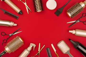 Hair cutting tools arranged in a circle on red background