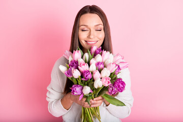 Wall Mural - Photo of joyful happy young attractive sweet lady smell flowers isolated on pastel pink color background