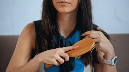 Wall Mural - cropped view of upset woman brushing hair