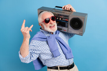 Poster - Photo of optimistic old grey hairdo man show rock sign hold boom-box wear spectacles blue shirt isolated on color background