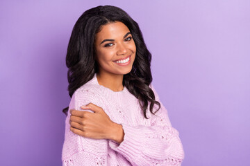 Wall Mural - Photo of shiny cute dark skin woman wear pink sweater smiling embracing herself isolated violet color background