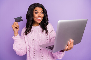 Wall Mural - Photo of charming funny dark skin lady dressed pullover holding modern device credit card isolated purple color background