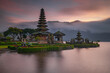 © Olga - Pura Ulun Danu Bratan temple in Bali island. Beautiful balinese temple during sunrise. Balinese landmark. Cloudy sky. Water reflection. Slow shutter speed. Bratan lake, Bali