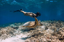 Freediver Woman Glides Underwater With Turtle In Sea. Snorkeling With Green Sea Turtle.