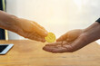 © thitisan - Hands of two businessmen are trading coin of bitcoin, symbolic coins of bitcoin, electronic money exchange, Digital currency, Finance and technology concept.