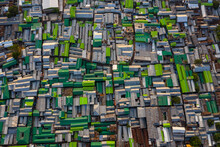 Aerial View Of A Large Slum Area Along Banani Lake, A Crowded Slum District With Houses Made Of Tin Roofs Against The Heat And Sun In Dhaka, Bangladesh.